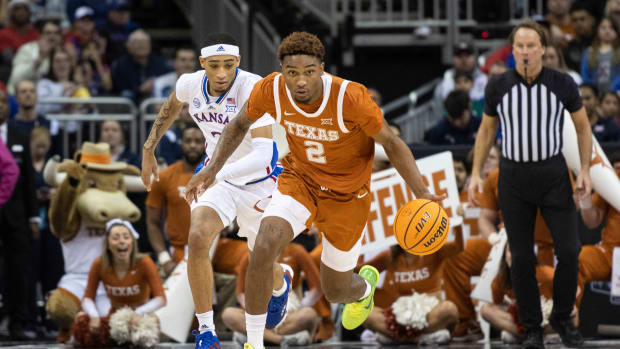 Texas Longhorns guard Arterio Morris (2) handles the ball while being chased by Kansas Jayhawks guard Dajuan Harris Jr. (3) in the first half at T-Mobile Center.